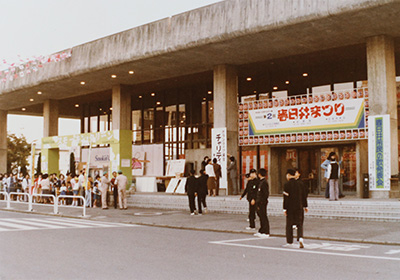 市民会館の入り口。右の緑色の立て看板には「春日井市民の歌発表会」と書かれています。